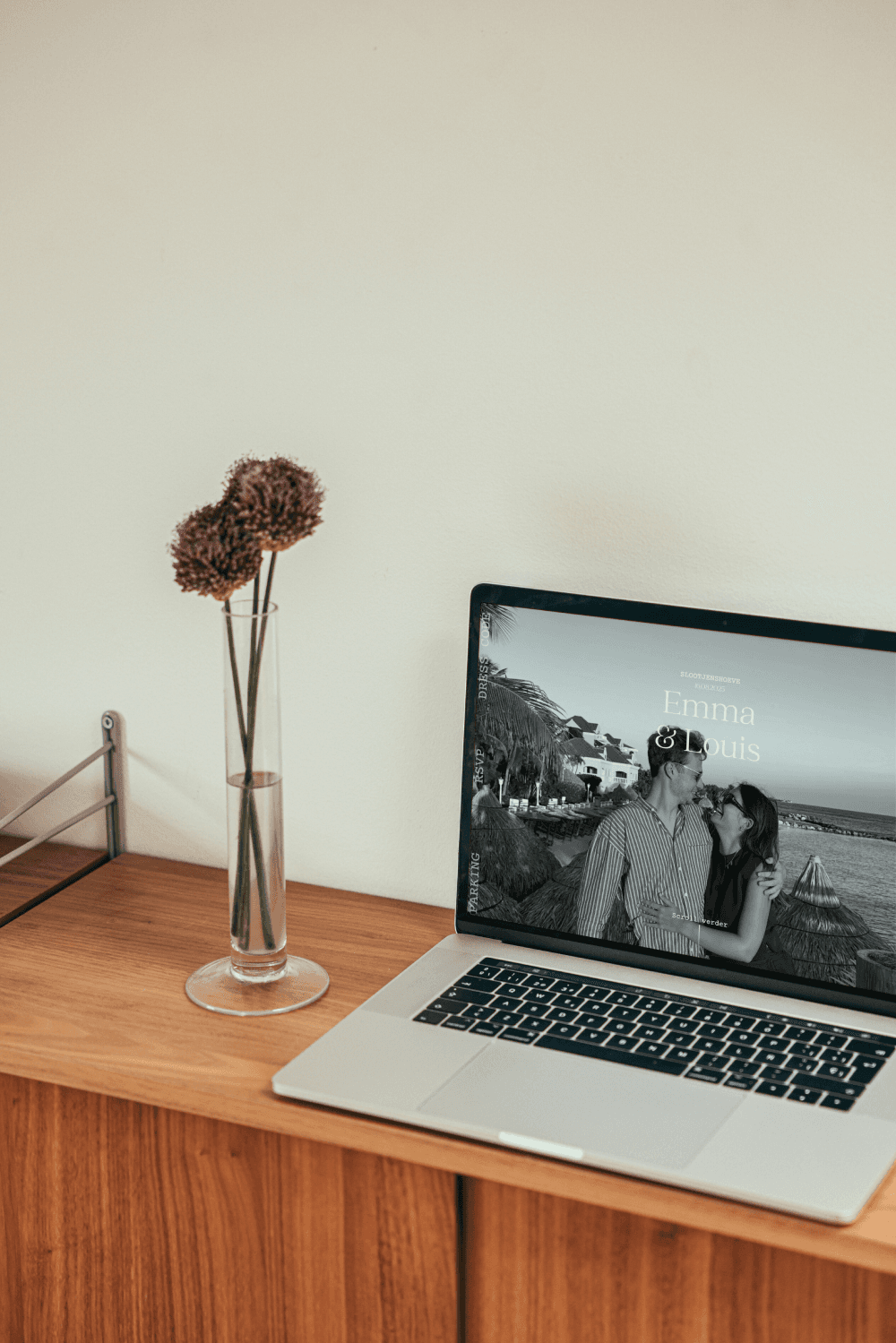 Laptop met trouwwebsite, op een houten kast.