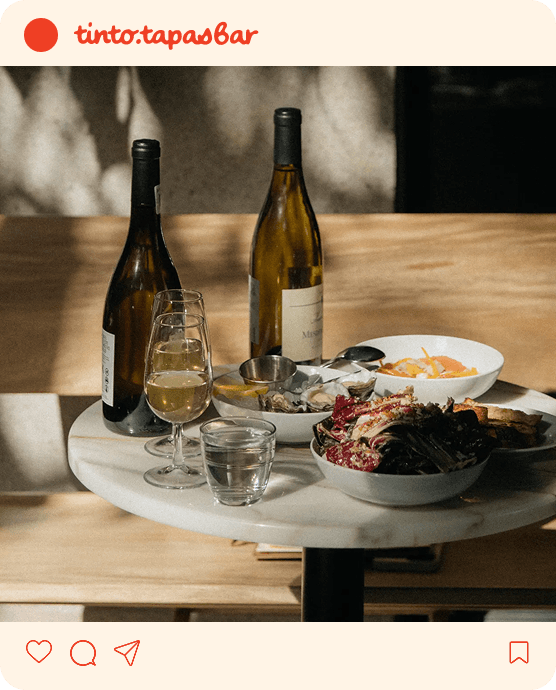 Instagram-post met een tafel met wijn en tapas op.